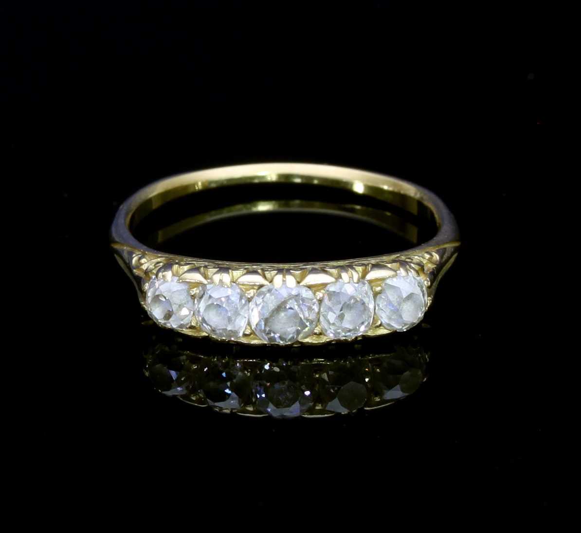 Lot 101 - A five-stone diamond ring, in a scroll