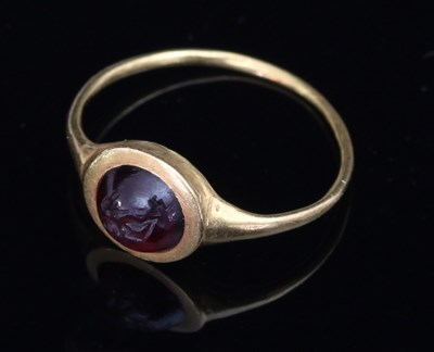 Lot 160 - An intaglio carved ring, the circular cabochon...