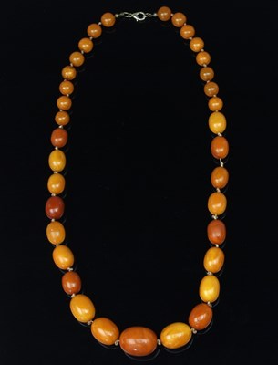 Lot 175 - An amber necklace of nineteen graduated oval...