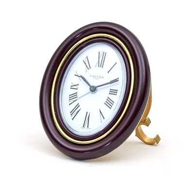 Lot 234 - A Cartier alarm clock, the oval dial with...