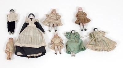 Lot 657 - A group of eight various miniature dolls, four...