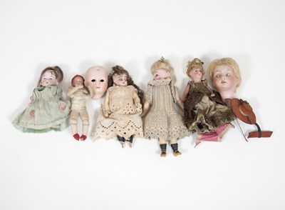 Lot 658 - Five miniature dolls and two bisque dolls...