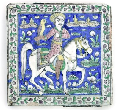 Lot 748 - A Qajar tile depicting a horseman with hawk,...