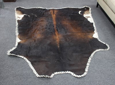 Lot 22 - A cowhide rug with wide stitch border,...