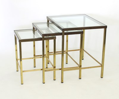 Lot 24 - A nest of three brass and glass tables, the...