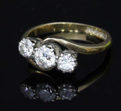 Lot 526 - A diamond three-stone ring in a crossover...