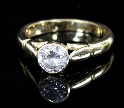 Lot 570 - A diamond solitaire ring in a rubover setting...