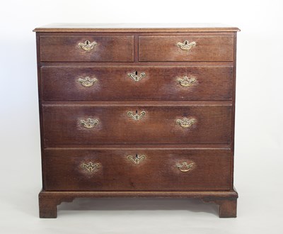 Lot 697 - A large George III oak chest of two short and...