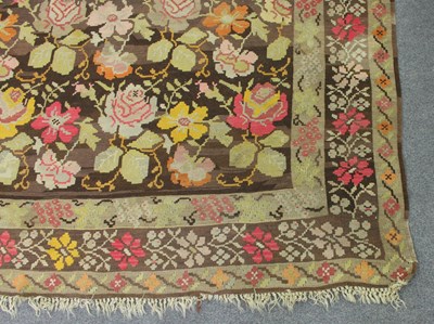 Lot 701 - A large Kelim rug, multi-coloured rosettes on...