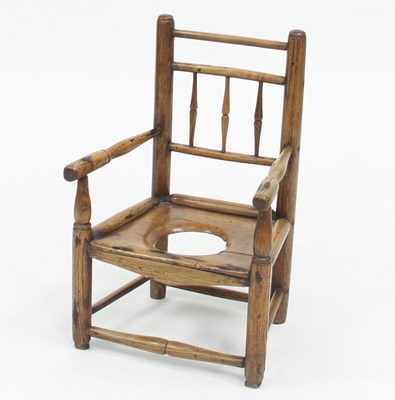 Lot 809 - A child's elm commode armchair with spindle back