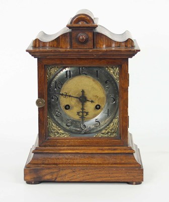 Lot 936 - An oak cased mantel clock, the square dial...