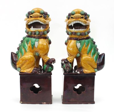 Lot 1068 - A pair of Chinese temple dogs, glazed in...