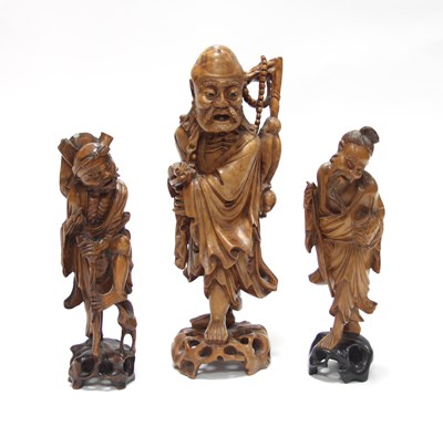 Lot 1069 - Three Chinese carved wood figures, each...