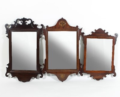 Lot 565 - A mahogany wall mirror, with carved ear pieces...