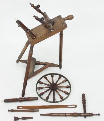 Lot 651 - A cherry wood spinning wheel, the bobbin...