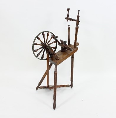 Lot 67 - A cherry wood spinning wheel, the bobbin...