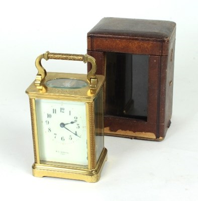 Lot 184 - A brass carriage clock with cream enamel dial...