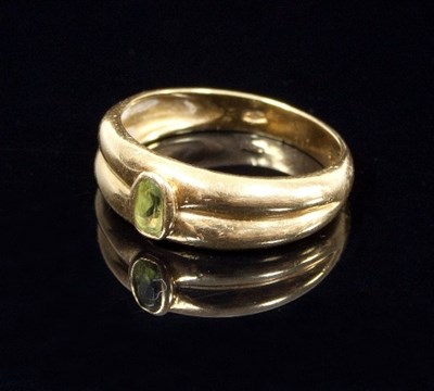 Lot 458 - A peridot dress ring, the oval peridot to an...