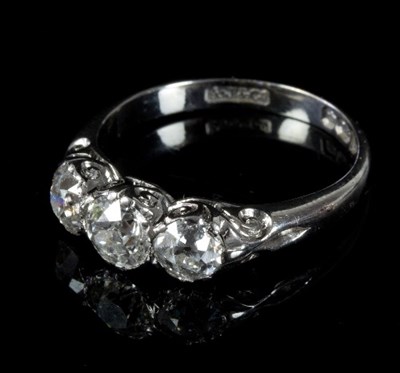 Lot 476 - A diamond three-stone ring in a scroll setting...