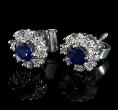 Lot 477 - A pair of sapphire and diamond cluster ear...