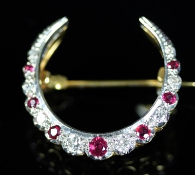 Lot 501 - A ruby and diamond crescent brooch, the...