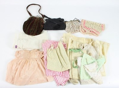 Lot 569 - A small quantity of dolls clothing, three...