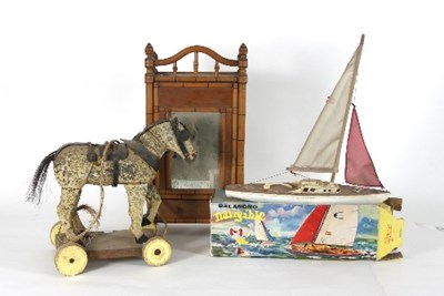 Lot 590 - A painted pull-along horse, wearing harness on...