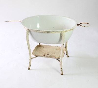 Lot 648 - A baby's oval white enamel bath with wrought...