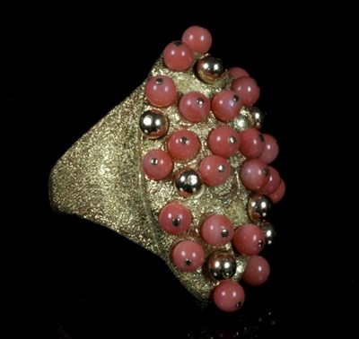 Lot 394 - A coral and gold dress ring of modern design,...