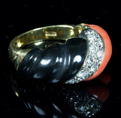 Lot 401 - A coral, diamond and onyx dress ring, the...