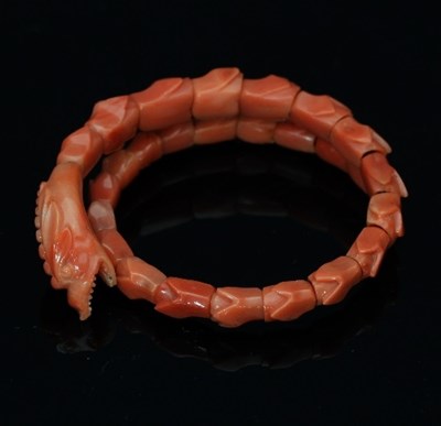 Lot 406 - A carved coral bangle, modelled as a serpent...