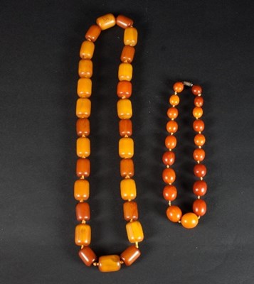 Lot 456 - A row of reformed oval amber beads, of...