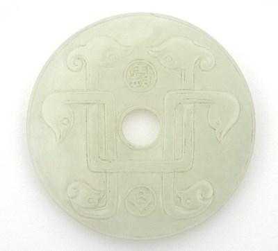 Lot 494 - A Chinese white jade bi disc, carved with six...