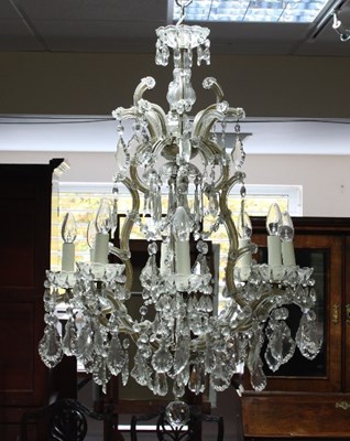 Lot 702 - A cut glass eight-light chandelier hung with...