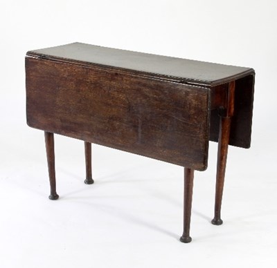 Lot 728 - An 18th Century oak two-flap table on round...