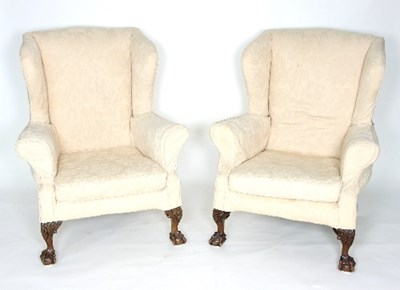 Lot 769 - A pair of wingback armchairs on carved claw...