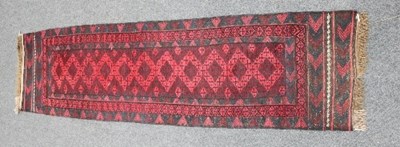 Lot 832 - An Afghan runner with geometric red ground...