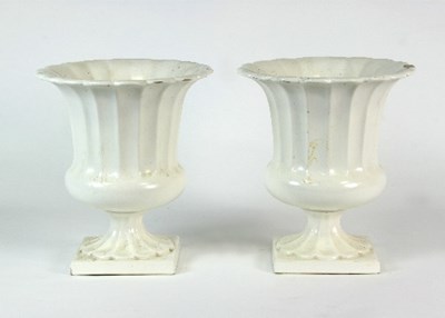 Lot 86 - A pair of Classical urns in white glazed...