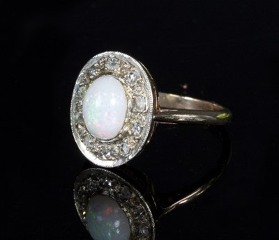 Lot 280 - An opal and diamond dress ring, the oval opal...