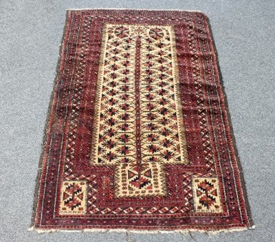 Lot 571 - A Balouch prayer rug, the central field of red...