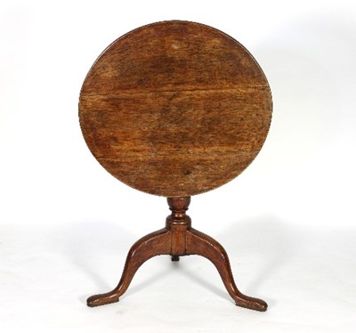 Lot 640 - A George III oak table on a turned column and...