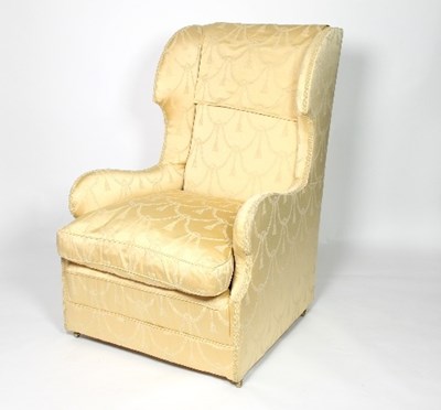 Lot 669 - A wingback armchair with loose seat cushion,...