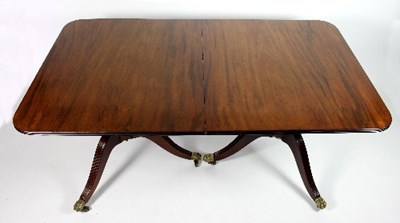 Lot 673 - A mahogany two-pillar dining table, the top in...