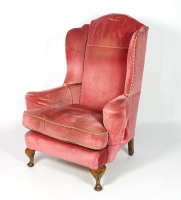 Lot 674 - A pink velvet upholstered wingback armchair...