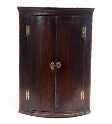 Lot 714 - A George III oak bowfront hanging corner...