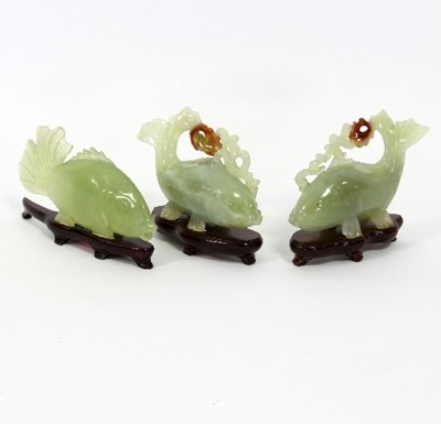 Lot 138 - Three jade models of fish, each on a wooden...