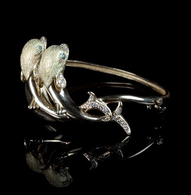 Lot 233 - An 18ct gold and gem set bangle, modelled as...