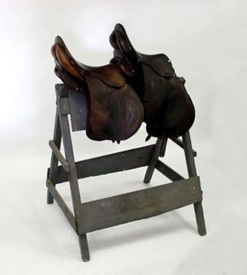 Lot 395 - Four leather saddles and a painted wooden...