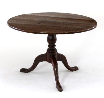 Lot 475 - A circular oak tripod table raised on a turned...