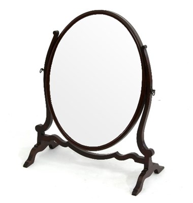 Lot 552 - An oval swing-frame toilet mirror on skeleton...